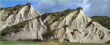 Ton-Mergel-Kegel in Potamida, im vordergrund ein Baum und ein Pferd zum Größenvergleich Ton-Mergel-Kegel in Potamida, im vordergrund ein Baum und ein Pferd zum Größenvergleich